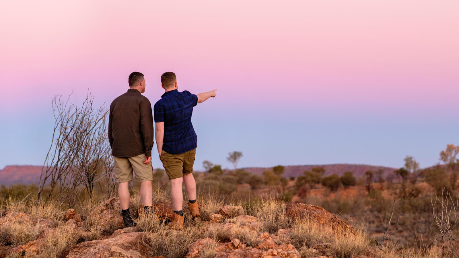 Two men hiking, one pointing to the distance