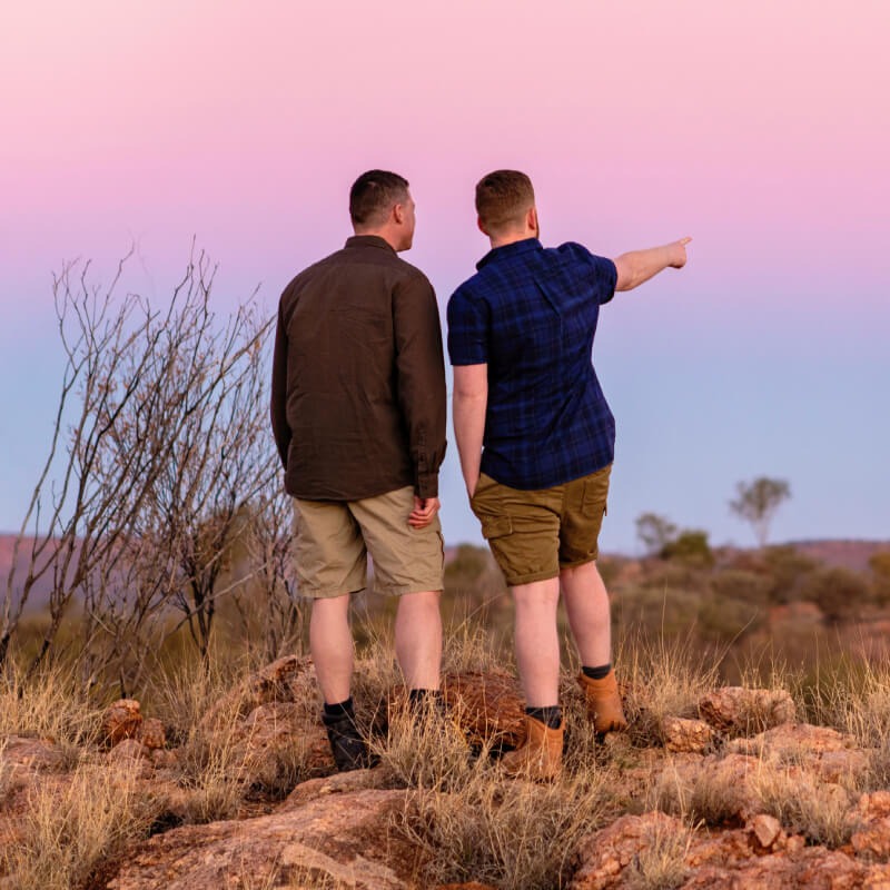 Two men hiking, one pointing to the distance