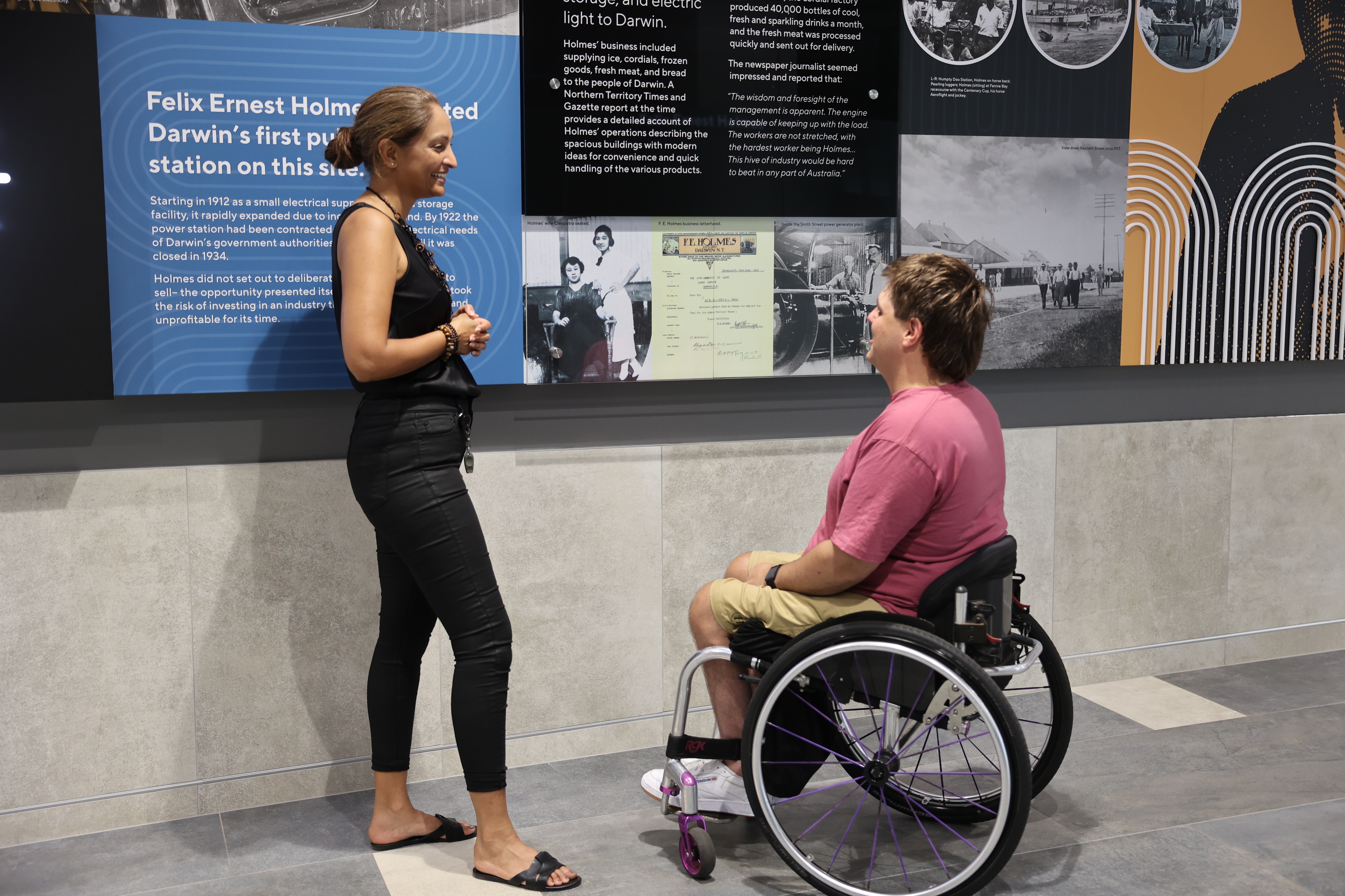 Woman standing and speaking to a man in a wheelchair