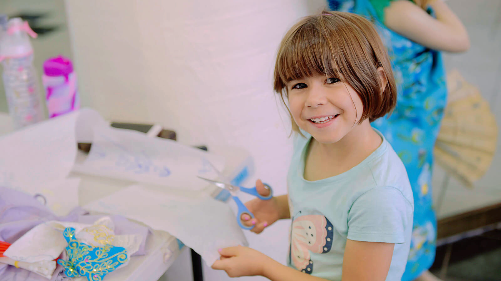 Child trimming paper with scissors