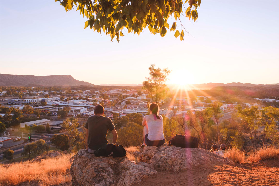 A couple watching the sunset from the lookout at ANZAC Hill in Alice Springs, Northern Territory. 