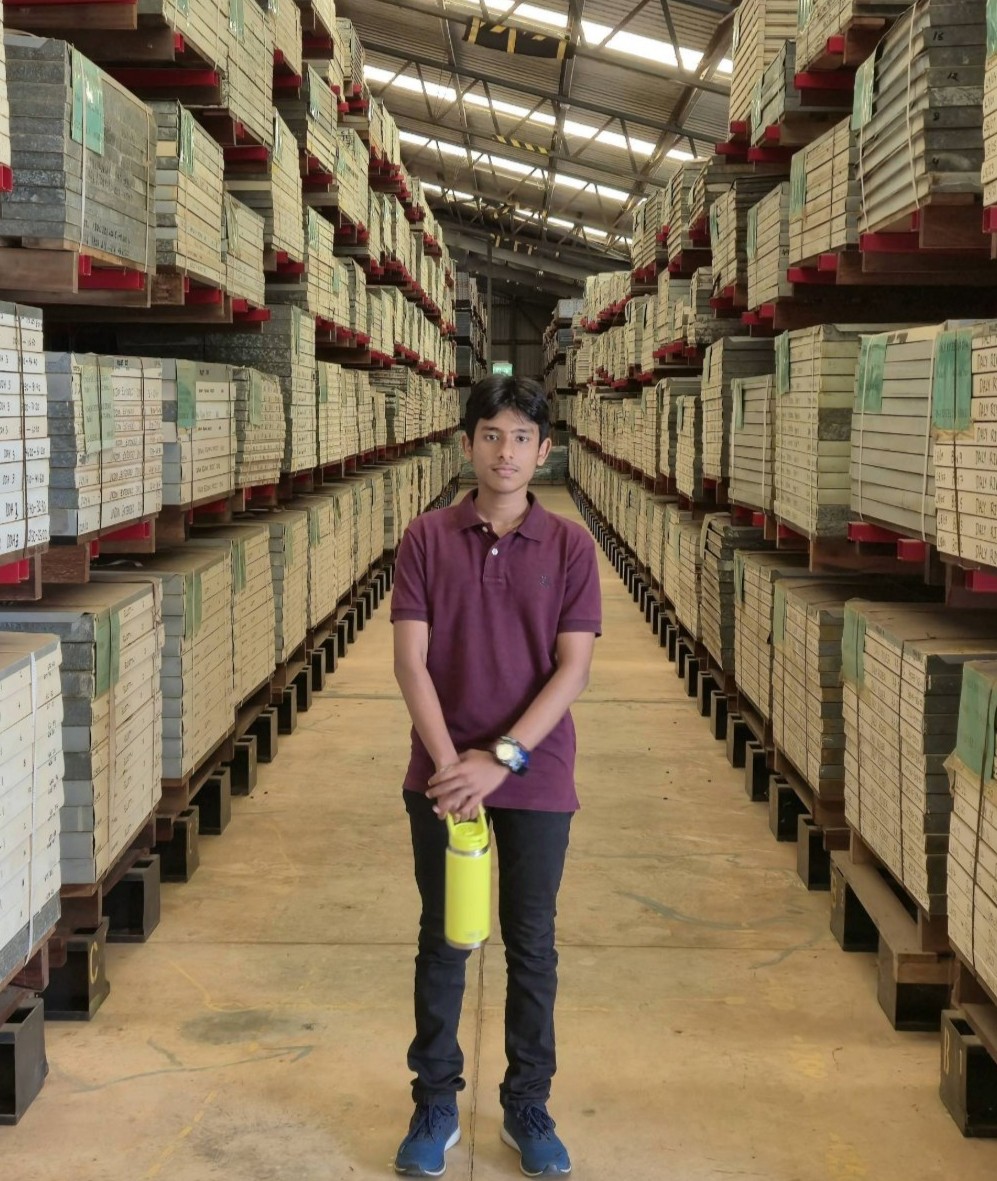 Person standing in a warehouse stocked with timber and building materials, showcasing an industrial workplace environment in the Northern Territory.