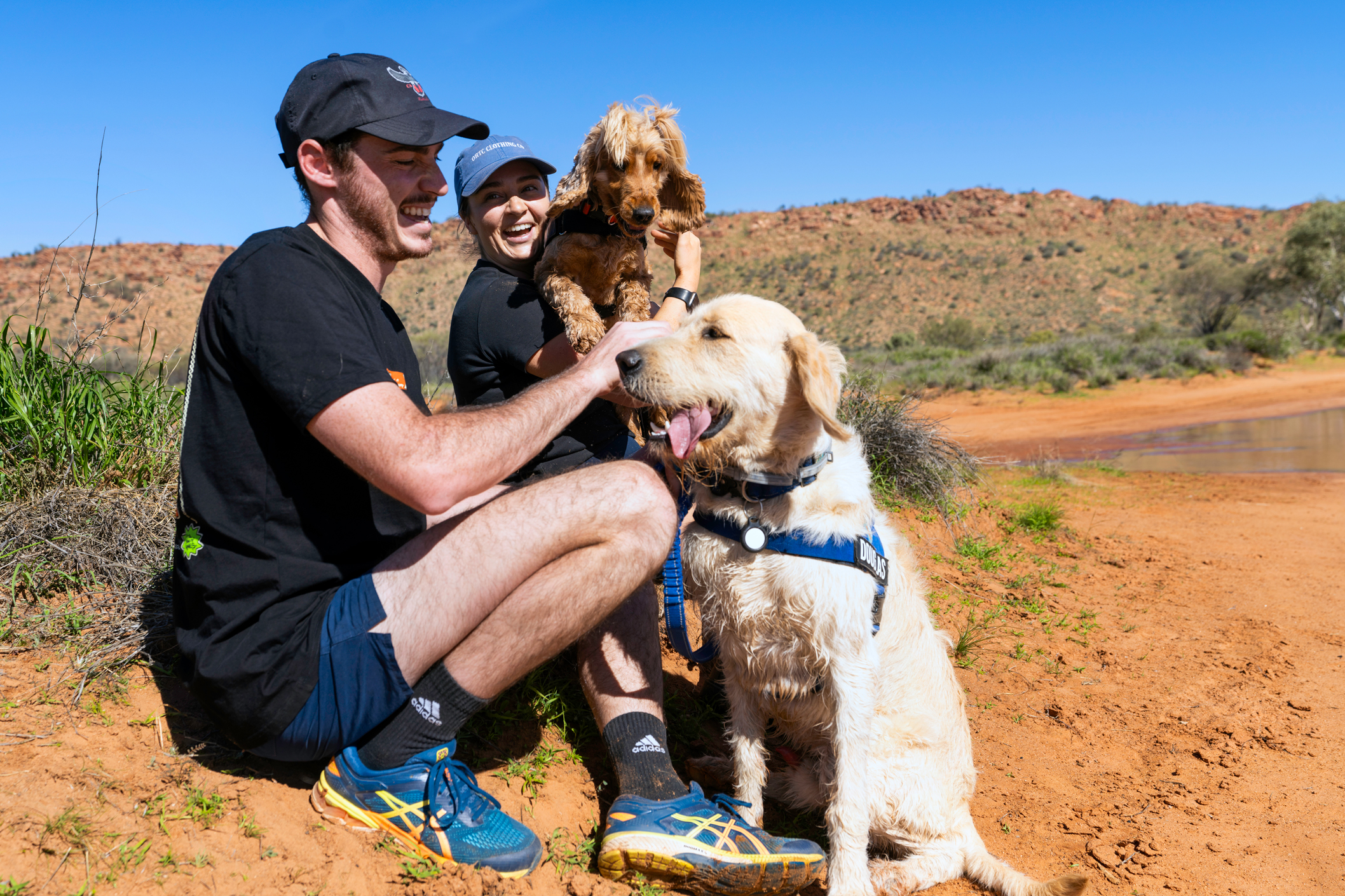 Couple holding their two dogs at the Claypans in Alice Springs NT