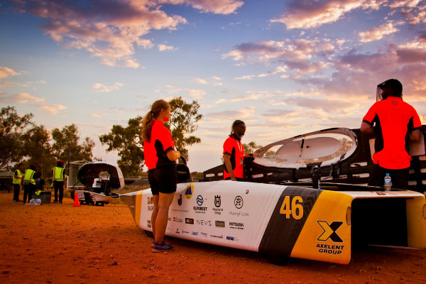 Team members adjust panels to maximise energy from the sun set at the World Solar Challenge in the NT