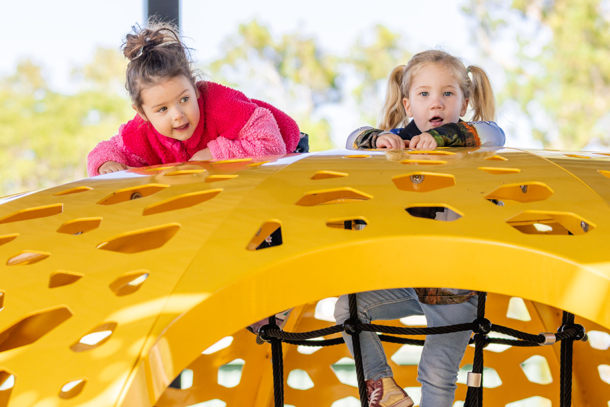 Children climbing play equipment