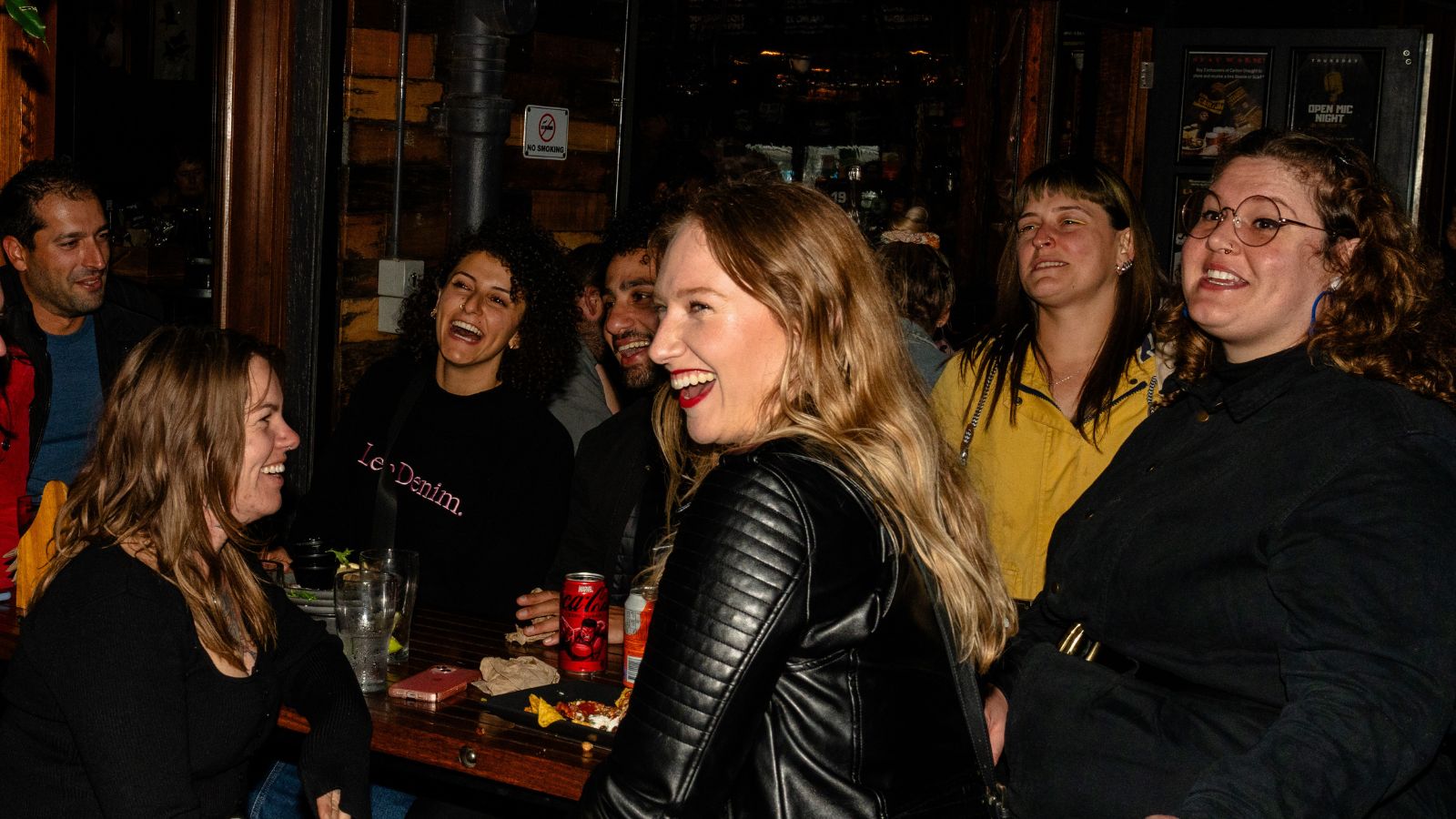 A group of friends laughing together at a bar.