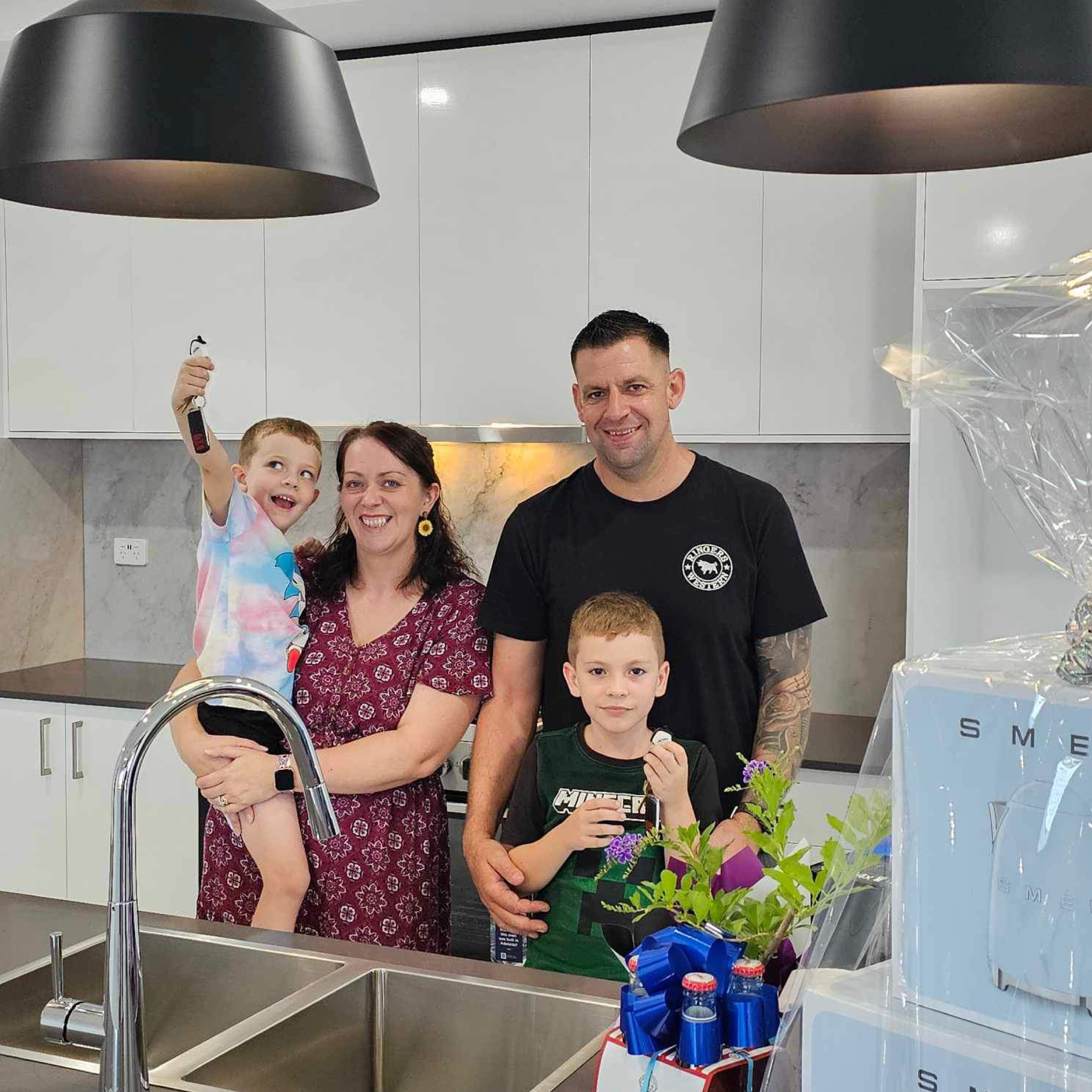 Family of four in new kitchen smiling at camera