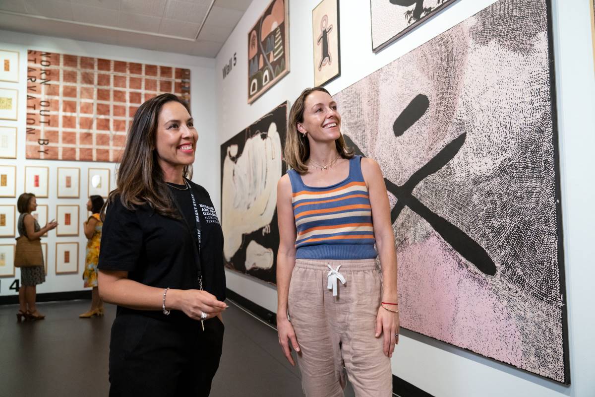 Museum employee and patron admire wall art at Museum and Art Gallery NT in Darwin Northern Territory