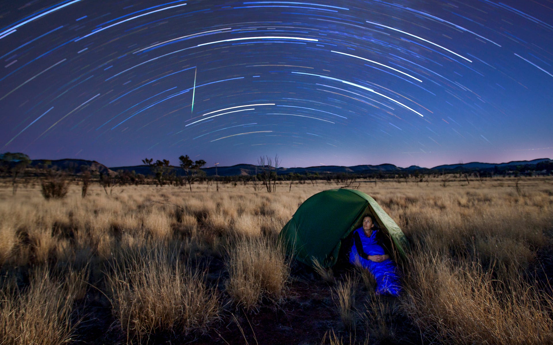 Star_timelapse_over_a_camping_woman_around_Alice_Springs