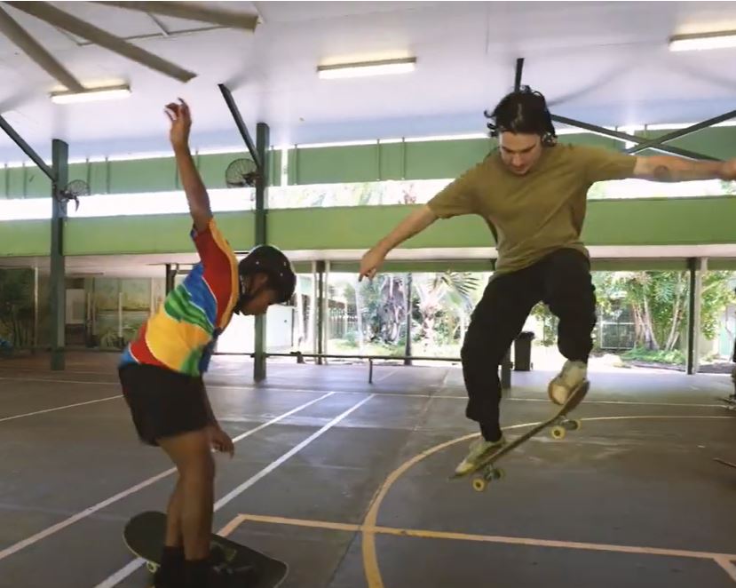 Two people skateboard tricks