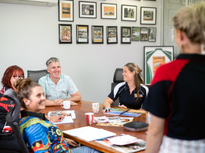 Community workers having a meeting around a conference table in an office in Katherine